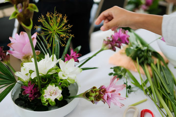 florist arranging flower bouquet in vase. floristry class course workshop
