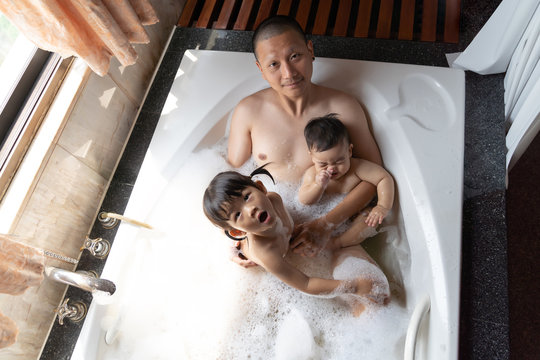 Asian family happy with father son and daugther playing with foam bubbles.