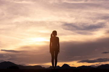 silhouette lonely girl standing on top of mountain