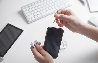 Hands with earphones and smartphone. People, Technology, Music