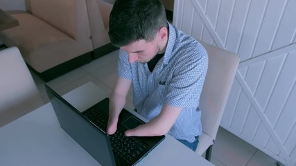 Freelancer computer online job. Disabled invalid man with amputated two stump hands in cafe works typing on laptop. Problem adaptation to life people disabilities. Independent handicapped young guy.