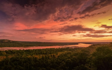 Naklejka na ściany i meble Top view of of Mekong river twilight around with forest and red sky background, sunset at Pha Taem National Park, Ubon Ratchathani, Thailand.