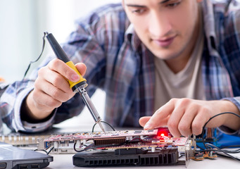 Professional repairman repairing computer in workshop