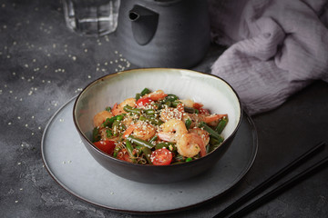 Noodles with shrimps and vegetables, Asian cuisine, Glass chinese noodles, Gray background, Selective focus