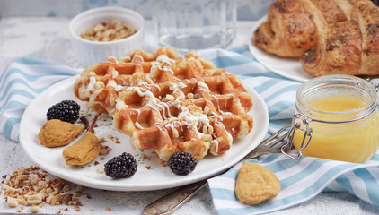 Belgian waffles with syrup, berries and honey, breakfast on a light background, Selective focus