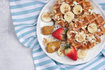 Belgian waffles with syrup, berries and honey, breakfast on a light background, Selective focus