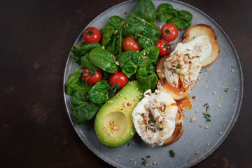 Toasts with avocado and poached egg, tomatoes and spinach, On a light gray background, Fresh morning breakfast