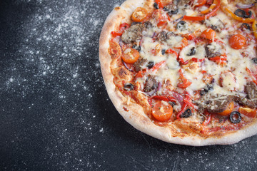 Pizza with vegetables on a dark background