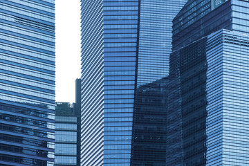 Office buildings windows. Blue glass architecture facade design with reflection of sky in urban...