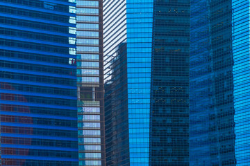 Office buildings windows. Blue glass architecture facade design with reflection of sky in urban...