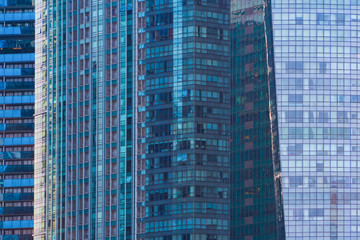 Office buildings windows. Blue glass architecture facade design with reflection of sky in urban...