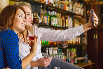 Girls in pub club taking self photo with phone