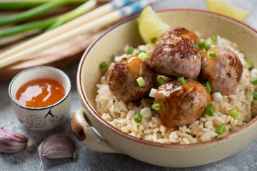Bowl of pork meatballs with rice cooked in chinese style, selective focus, close-up, studio shot