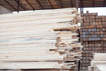 Boards in stock. Building materials from wood. The result of logging under the board. Beams for building a house.