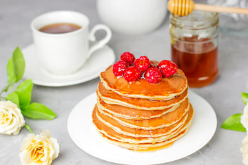 stack of pancakes with raspberry and honey