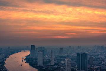 Bangkok city with skyscrapers and Chao Phraya river at sunset