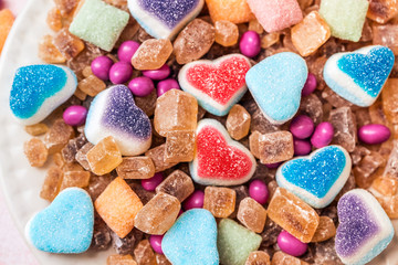Scattered candy and sugar sweets in the shape of heart, cute tasty jelly beans