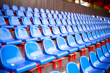 Fototapeta premium Rows of seats in the stadium. Blue seats in the sports arena. A place to watch sports.