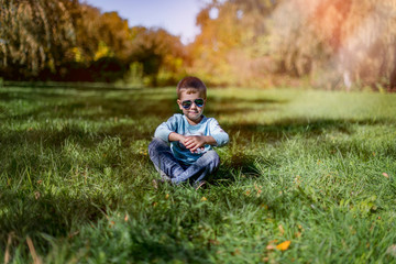 Naklejka na ściany i meble young man sitting on the grass in park