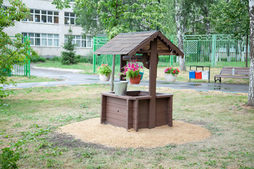Decorative well on the site. Design decision to decorate the park. Well with a bucket.