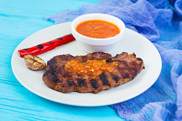 Grilled juicy pork steak on wooden background.