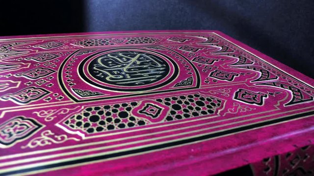 Red Quran on a dark background, close-up. Islam. 