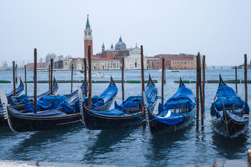 Fototapeta na wymiar Covered parked gondolas in Venice, Italy