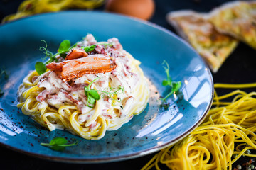 fresh italian spaghetti carbonara with tasty ingredients - cream, egg, bacon