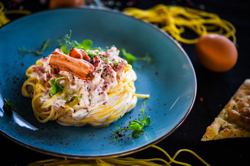 fresh italian spaghetti carbonara with tasty ingredients - cream, egg, bacon