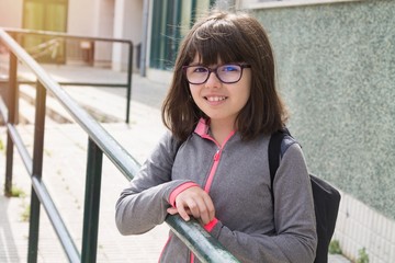 student leaning on the railing of the school or campus
