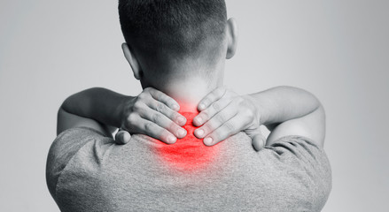 Strong man with neck pain, back view
