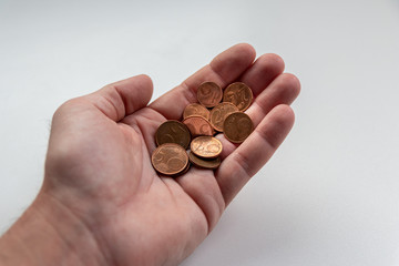 Männerhand eines Europäers hält EURO-Münzen zur Bezahlung mit Bargeld, Schuldenbegleichung oder...