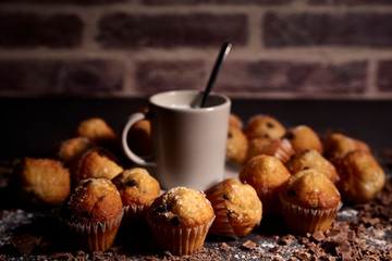 group of muffins next to a cup of milk