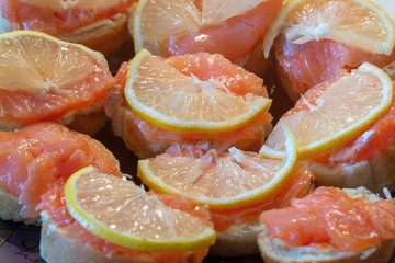 Sandwiches of slightly salted red fish with lemon. Spices and fish