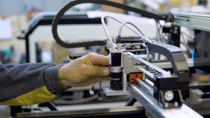 engineer removing nozzle from machine at surface mount Technology(SMT) for maintenance and clearing, place to electronic equipment, blur background
