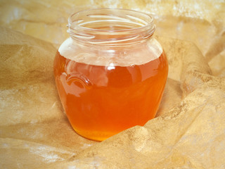 jar of  fresh flower honey  around golden background