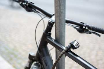 bicycle detail with a lock chained to a metal pole, theft protection concept
