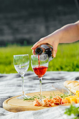 picnic in nature a light meal under wine, on a wooden background two glasses of red wine