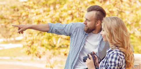 Man and woman having date outdoor. Girl wit a photo camera and her boyfriend.