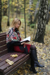 young woman reading a book in the park