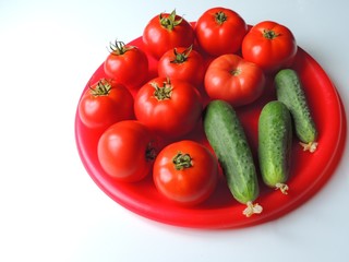 tomatoes and cucumbers on plate isolated on white
