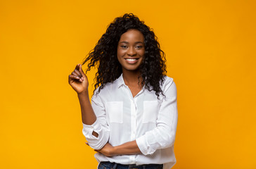 Beautiful afro girl playing with her curly hair