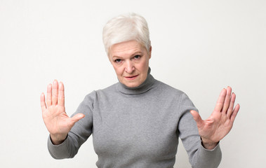 Senior woman practicing hypnosis, looking mysteriously at camera