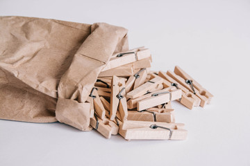 Wooden clothespins in paper bag on white background. Place for your text