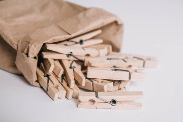 Wooden clothespins in paper bag on white background. Place for your text
