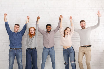 Obraz premium Friends standing with raised hands, celebrating succees