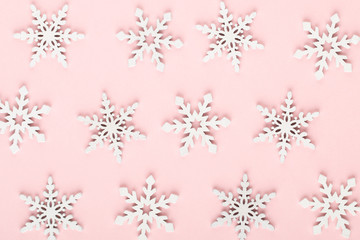 Christmas background. White snow decorations on a pink background.