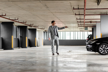 Convenient way. Businessman in grey suit parks his car at parking lot. Copy space on the right and on the left side