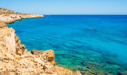  colorful pristine nature of the coast of Cyprus cape cavo greco with clear blue water and yellow rocks
