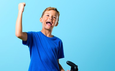 Lucky kid playing the console on blue background